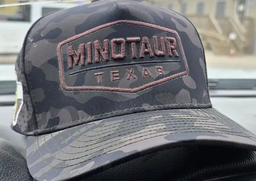 Dark camo cap with a Minotaur Texas badge embroidered on the front
